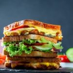 Layered sandwich with vegetables, ham and cheese